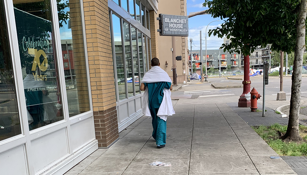 Homeless%20woman%20walking%20in%20hospital%20scrubs.jpg